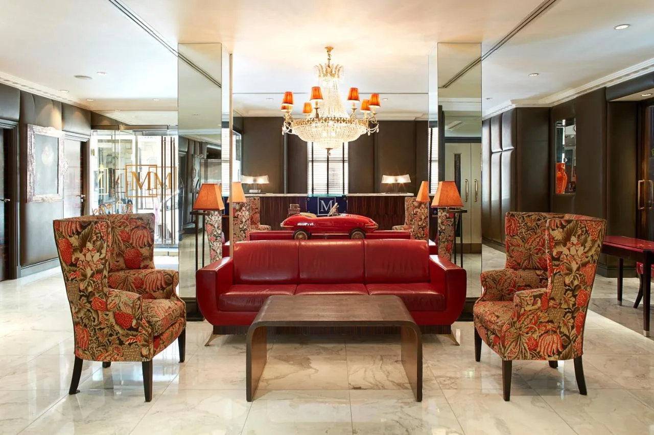 a living room with a red couch and chairs at The Mandeville Hotel in London