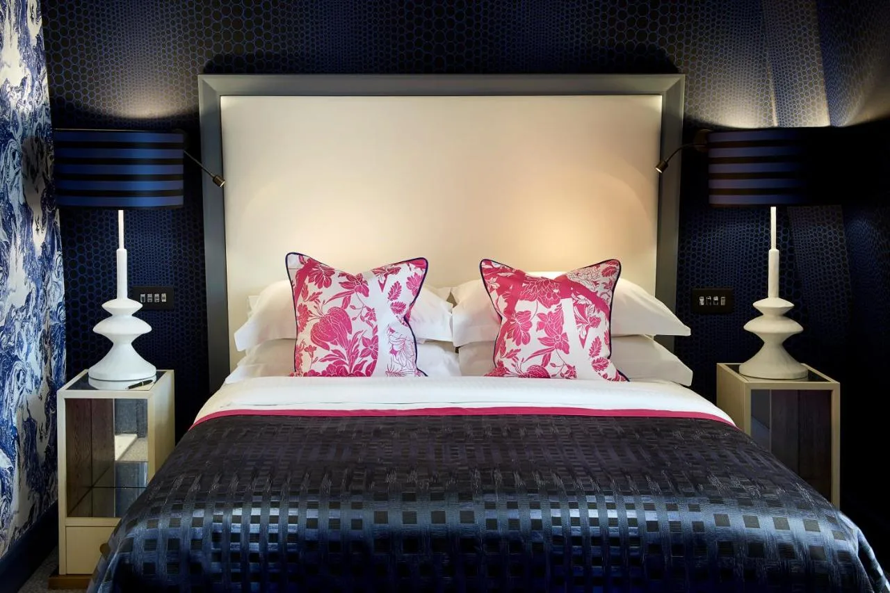 a bedroom with a large bed with pink pillows at The Mandeville Hotel in London
