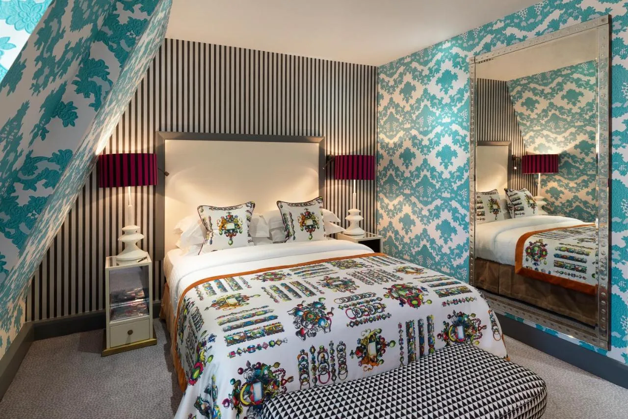 a bedroom with a bed and a mirror at The Mandeville Hotel in London