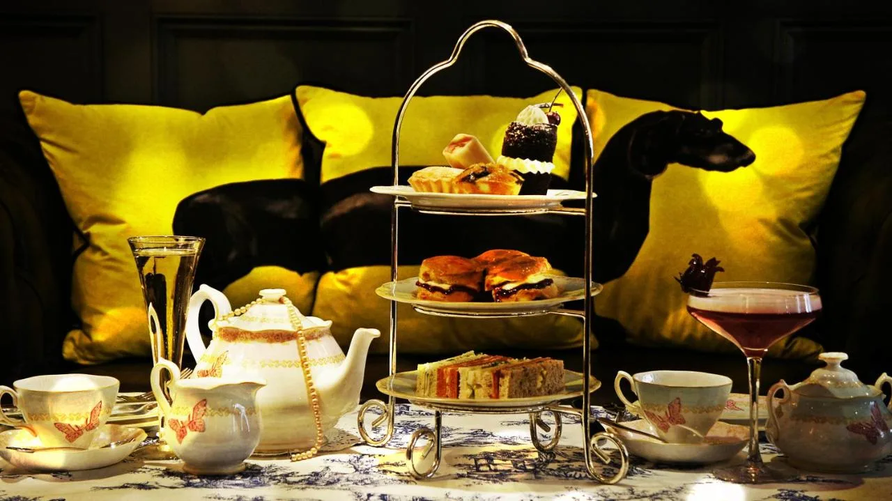 a table topped with plates of pastries and tea sets at The Mandeville Hotel in London
